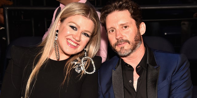 Kelly Clarkson and Brandon Blackstock pose at an event together.