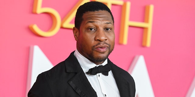 Jonathan Majors looks at the camera on the red carpet in a classic tuxedo at the 54th NAACP Image Awards