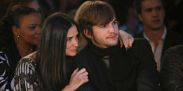 Demi Moore throws her arm around Ashton Kutcher at a fashion show