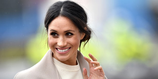 Meghan Markle in a light sand jacket waves in Ireland