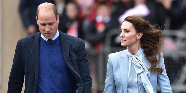 Prince William and Kate Middleton wearing various shades of blue outside