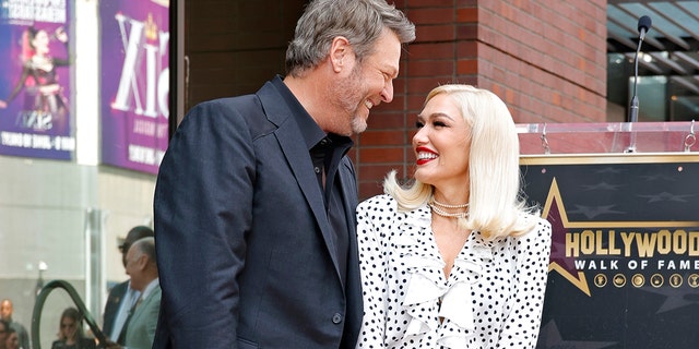 Gwen Stefani and Blake Shelton smiling at each other