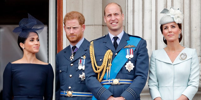 Meghan Markle, Prince Harry, Prince William and Kate Middleton in royal regalia standing on the balcony of Buckingham Palace