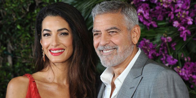 Amal and George Clooney smile for a photo