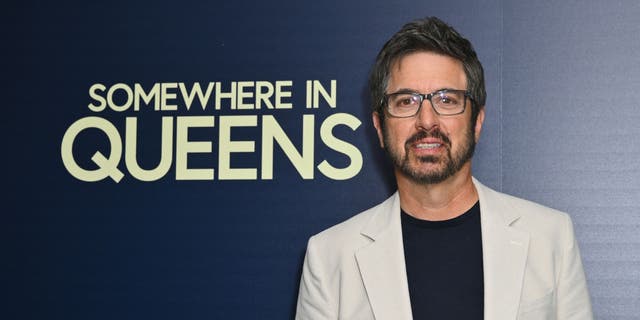 Ray Romano in front of signage for his movie "Somewhere in Queens."