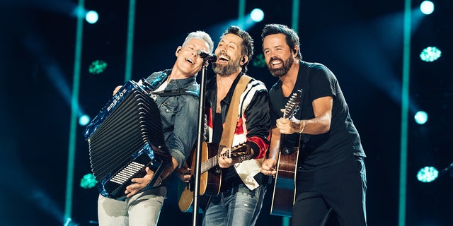 Old Dominion plays on stage at CMA Fest and all three (Trevor Rosen, Matthew, Ramsey and Brad Tursi) lean into the microphone