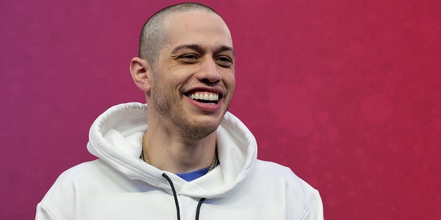 Pete Davidson smiles in a white sweatshirt In Las Vegas at the Pro Bowl Game