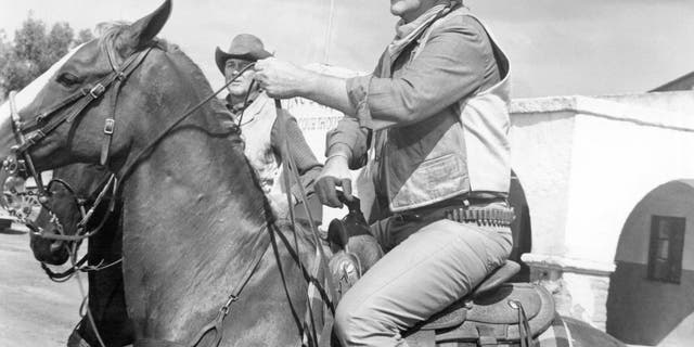 John Wayne on horseback in a scene from Rio Lobo