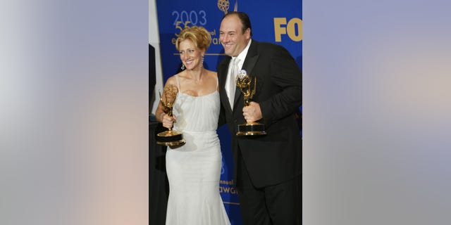 Edie Falco and James Gandolfini holding Emmys backstage at the Emmy Awards