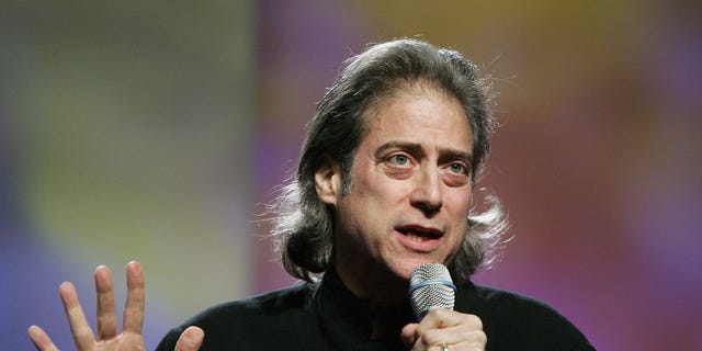 Richard Lewis with a microphone performing stand up