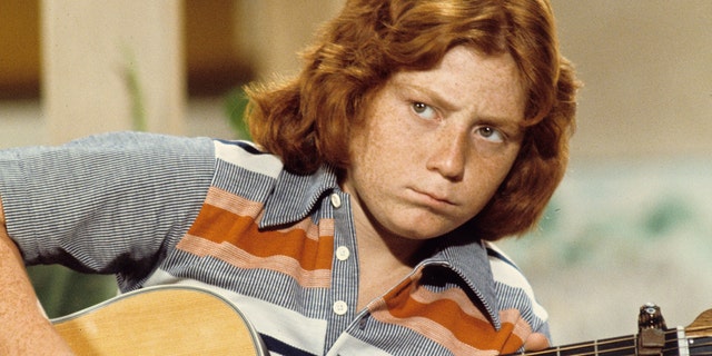 Danny Bonaduce strums a guitar on The Partidge Family