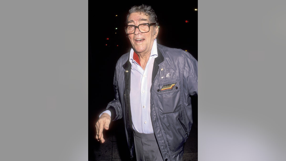 Dean Martin smiling in a blue jacket and a white shirt.