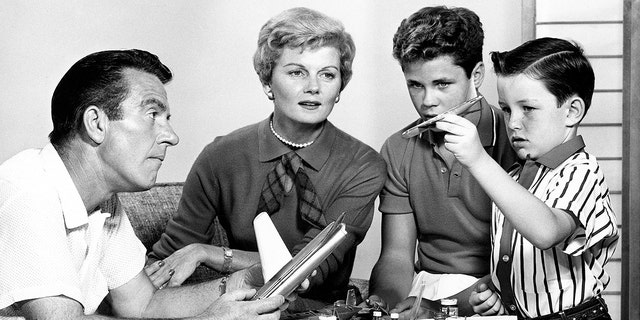 The cast of Leave It to Beaver sitting together with toy airplanes