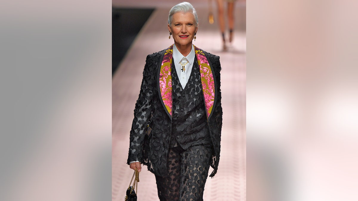 Maye Musk wearing a black suit walking the runway