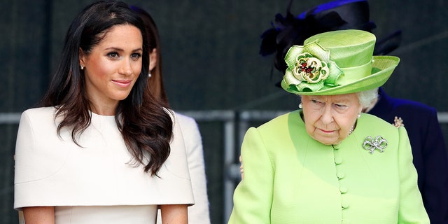 Meghan Markle in a beige dress sitting next to Queen Elizabeth in a lime green dress