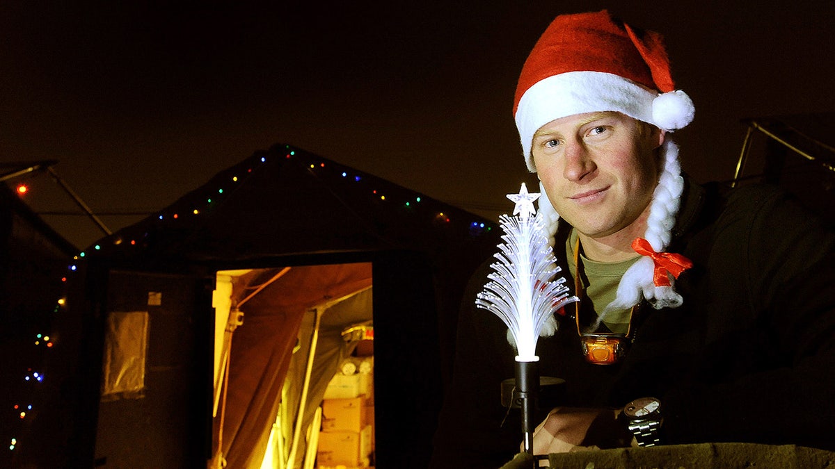 Prince Harry wearing a santa hat and white pigtails