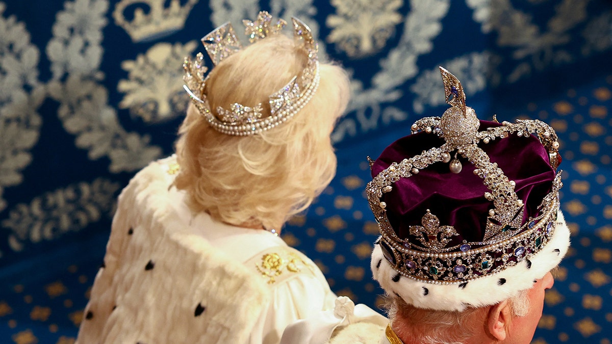 King Charles and Queen Camilla with their backs turned showing their crowns.