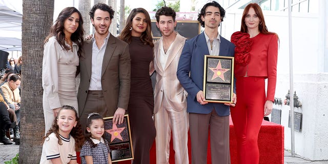 Danielle Jonas, Kevin Jonas, Priyanka Chopra, Nick Jonas, Joe Jonas, Sophie Turner, and (front) Alena Rose Jonas and Valentina Angelina Jonas attend The Hollywood Walk of Fame star ceremony honoring The Jonas Brothers on January 30, 2023 in Hollywood, California. 