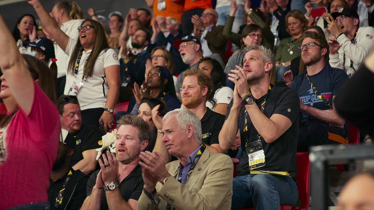 Prince Harry in a crowd smiling