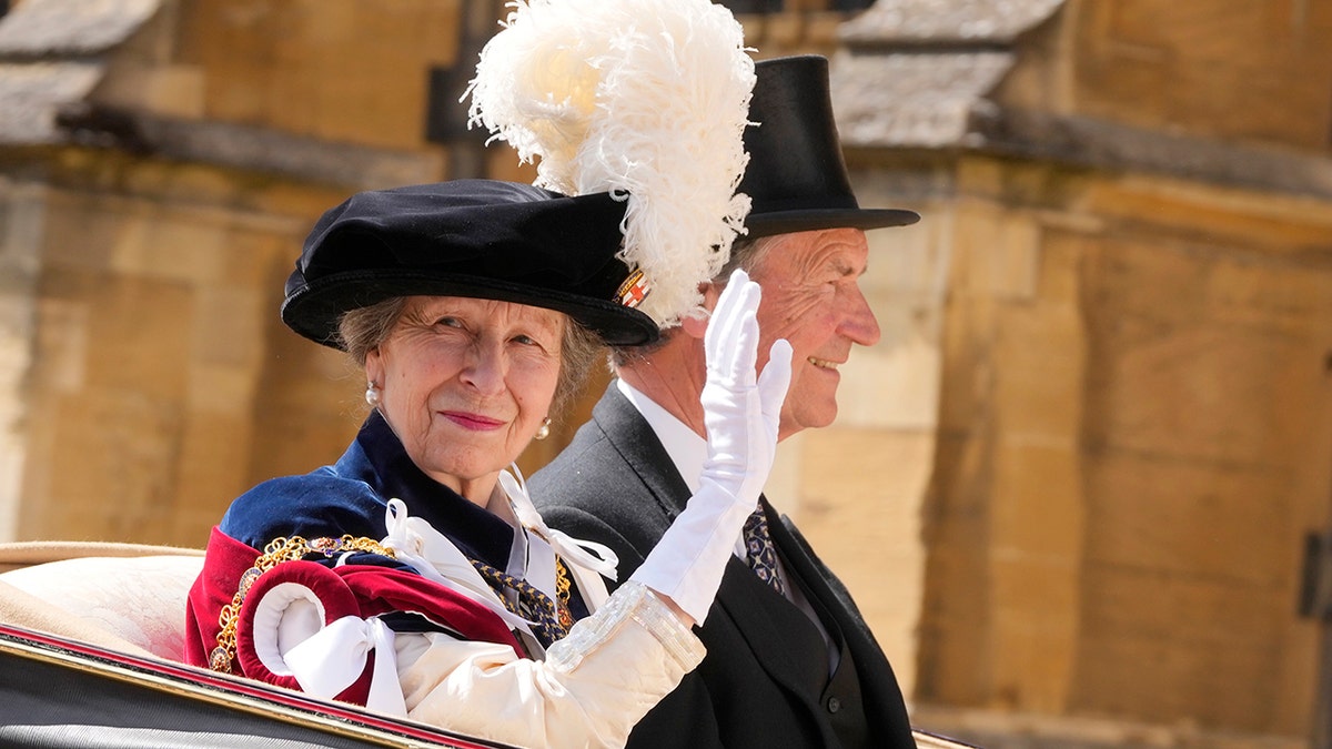 Princess Anne waving from a horse drawn carriage