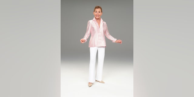 Judge Judy in a pink jacket and white pants