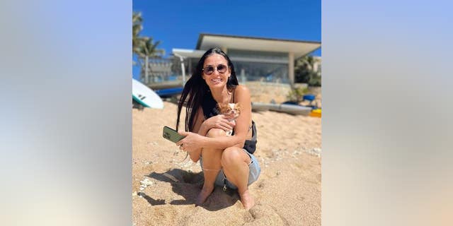 Demi Moore holding her dog on the beach