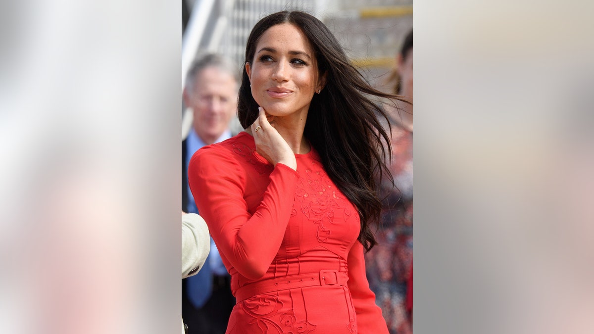 Meghan Markle wearing a red long sleeved dress