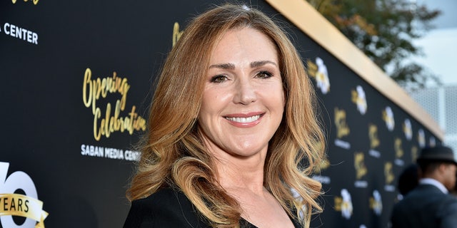 Peri Gilpin smiles on the carpet in a black dress