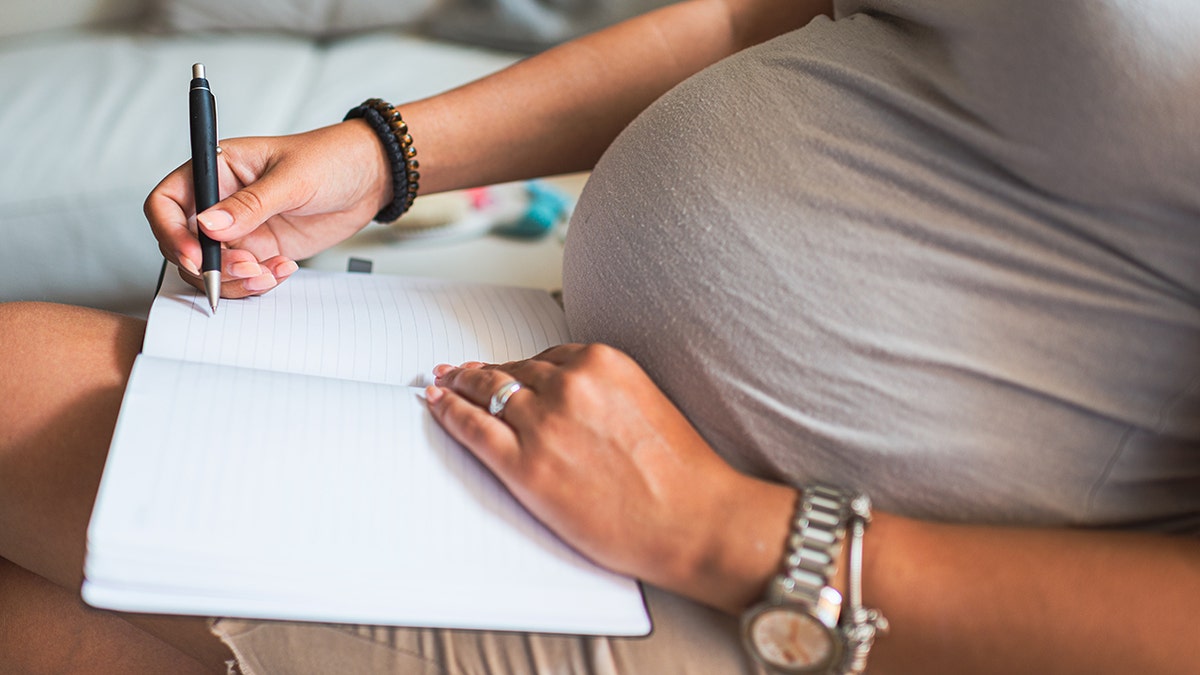 pregnant mom writes list of baby names