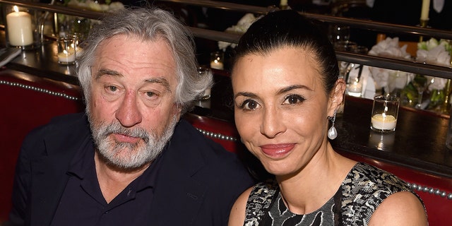 Robert De Niro in a black shirt sits next to his daughter Drena De Niro