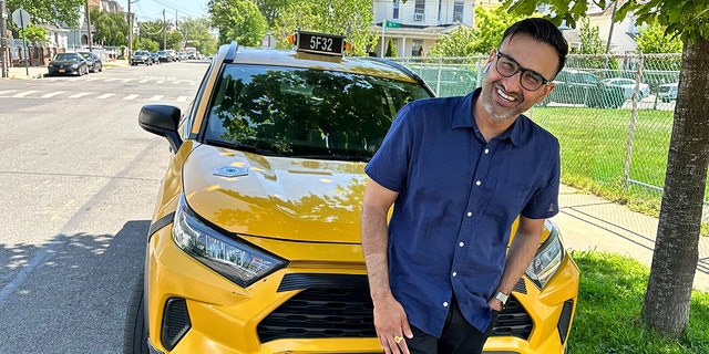 Cab driver Sukhcharn Singh posing in front of his taxi